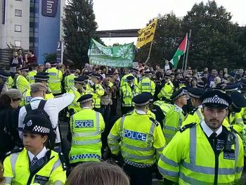 Large numbers of police block a crowd of protesters